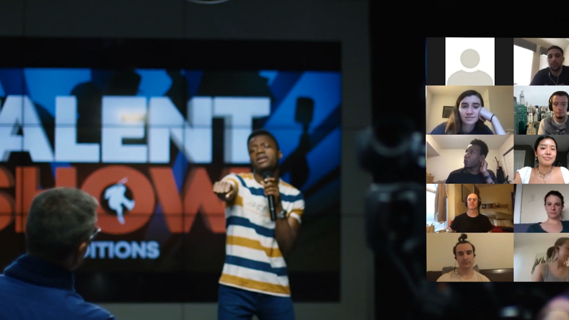 A group of people in front of a screen with the word talent show on it.