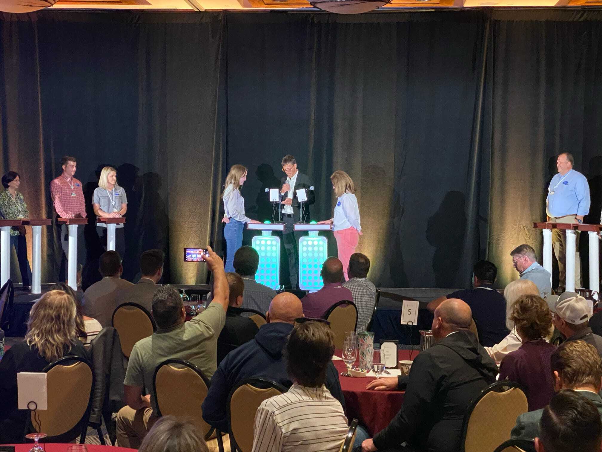 A group of people standing in front of a stage.