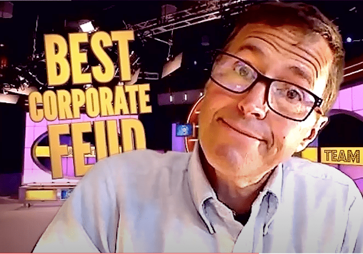 A man in glasses with the words best corporate feud.