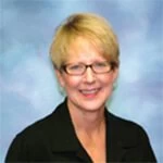 A woman wearing glasses and a black shirt.