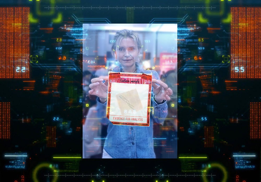 A man is holding up a piece of paper in front of a computer screen.