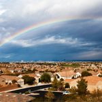 A rainbow is seen over a residential neighborhood.