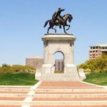 A statue of a man riding a horse in a park.