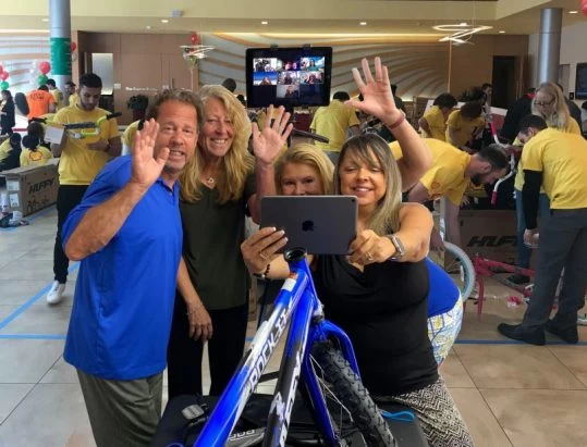 A group of people posing for a photo with a bicycle.