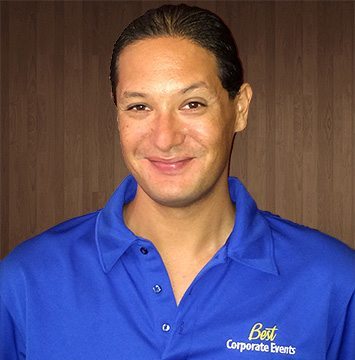 A man in a blue shirt smiling at the camera.