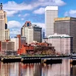 The skyline of a city with a river in the background.