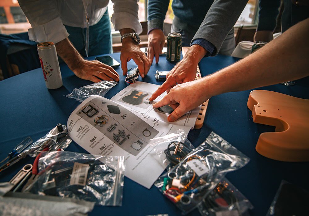 A group of people working on electronics at a table.