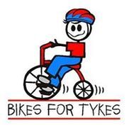 A cartoon stick figure riding a tricycle with the text "BIKES FOR TYKES" underneath. The figure is wearing a red shirt, blue pants, and a red and blue hat.