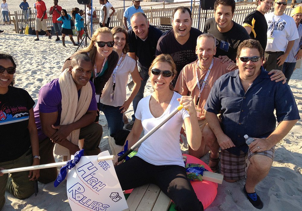 A group of people posing for a picture on the beach.