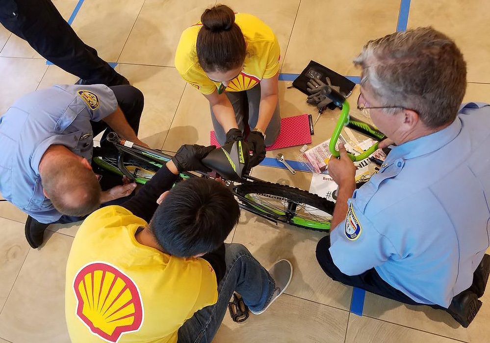 A group of people working on a bicycle.