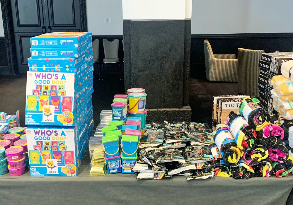 A table filled with numerous items, including toys for donation.