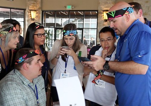 A group of people looking at a cell phone.