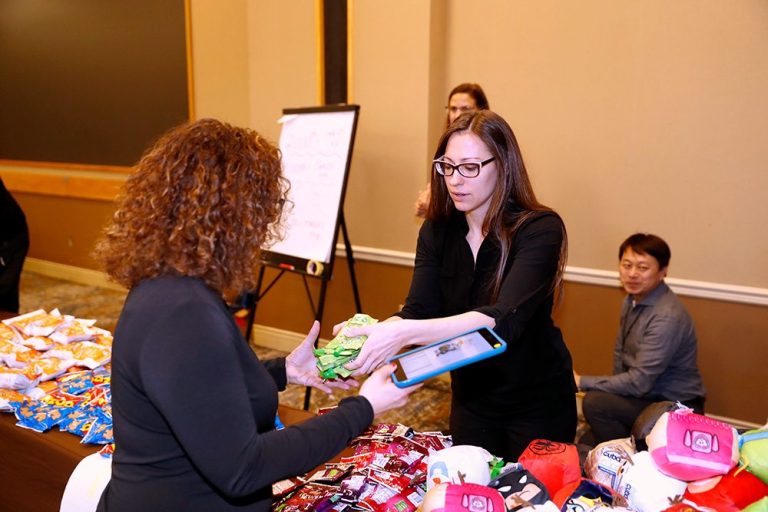 A woman handing out food to a group of people.