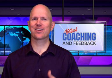 A man is standing in front of a television screen with the words coaching and feedback.