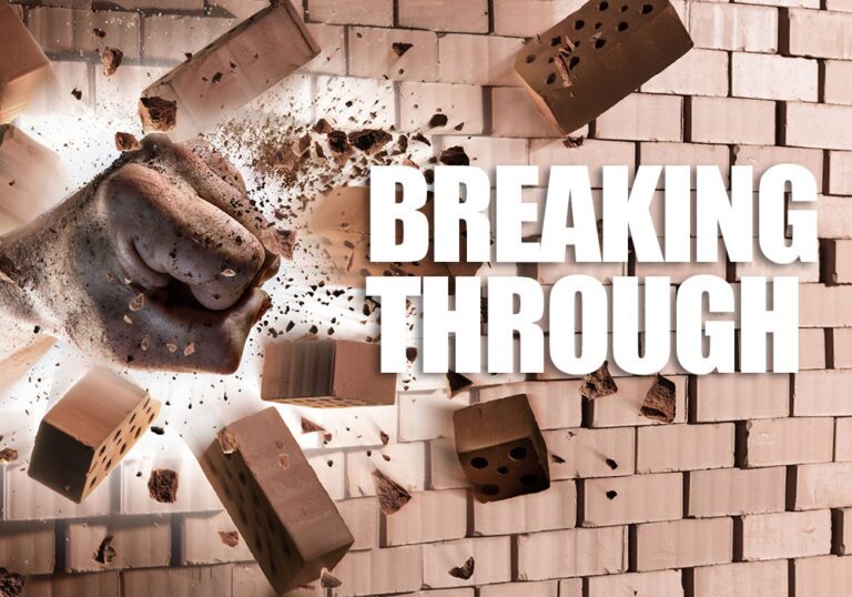 A fist punches through a brick wall, scattering debris like a board breaking, with the words "BREAKING THROUGH" in bold white letters on the right side.