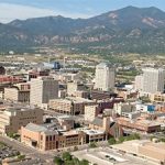 An aerial view of the city of colorado with mountains in the background.