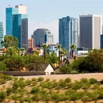 A city skyline with tall buildings and trees in the background, perfect for team building activities in Tempe, AZ.