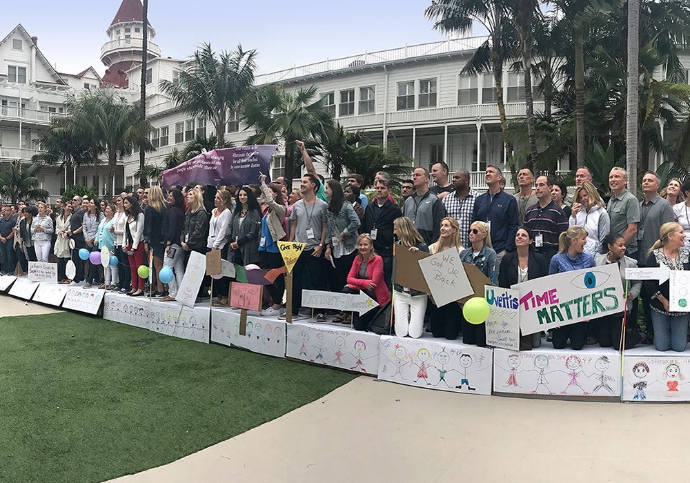 A group of people holding signs in front of a hotel.