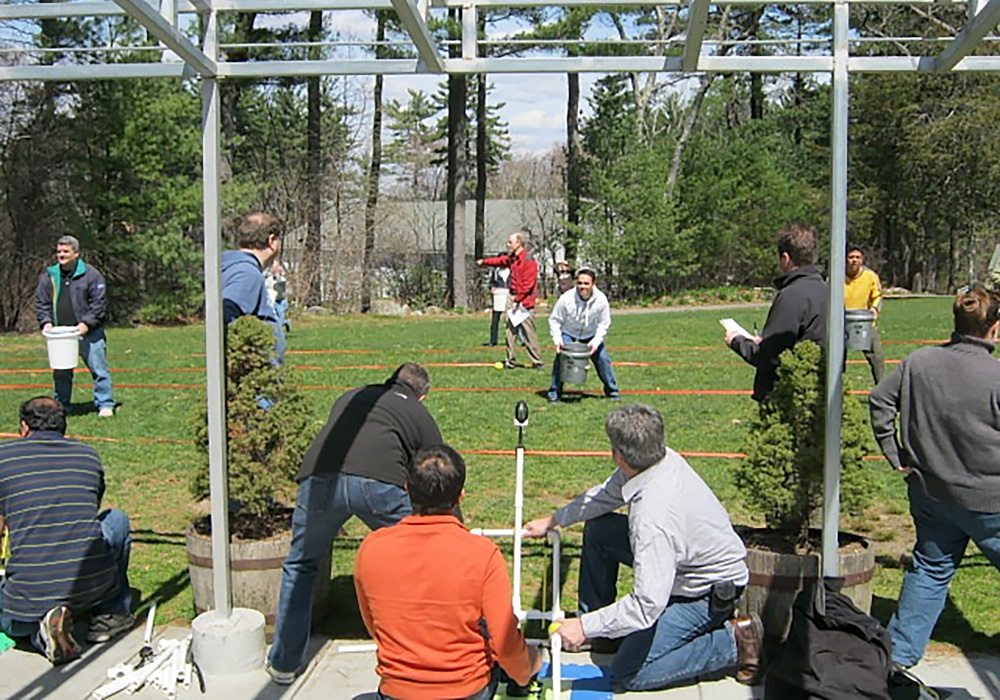 A group of people standing in a grassy area.