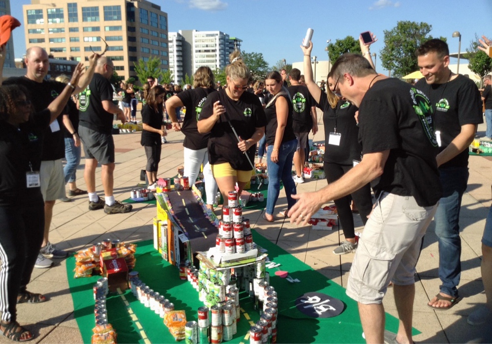 A group of people standing around a large lego model.