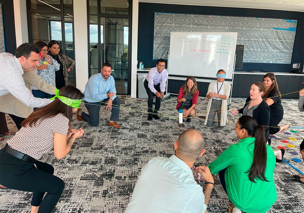 A group of people playing a game in an office.