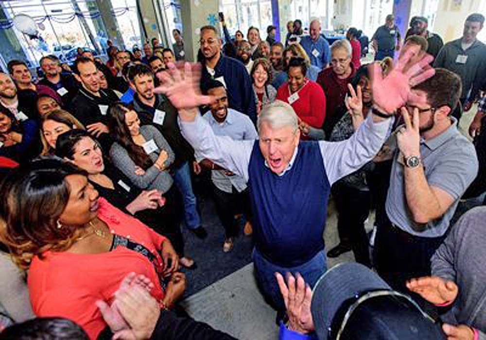 A crowd of people with their hands up in the air.