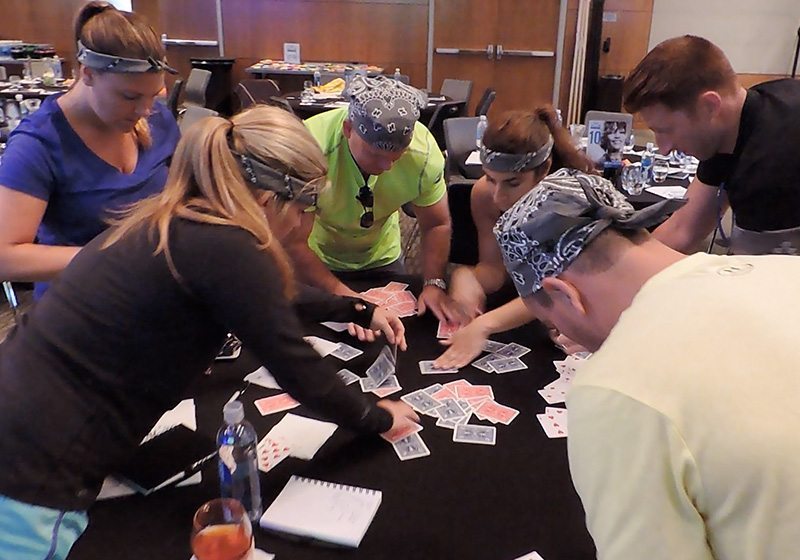 A group of people playing cards at a table.