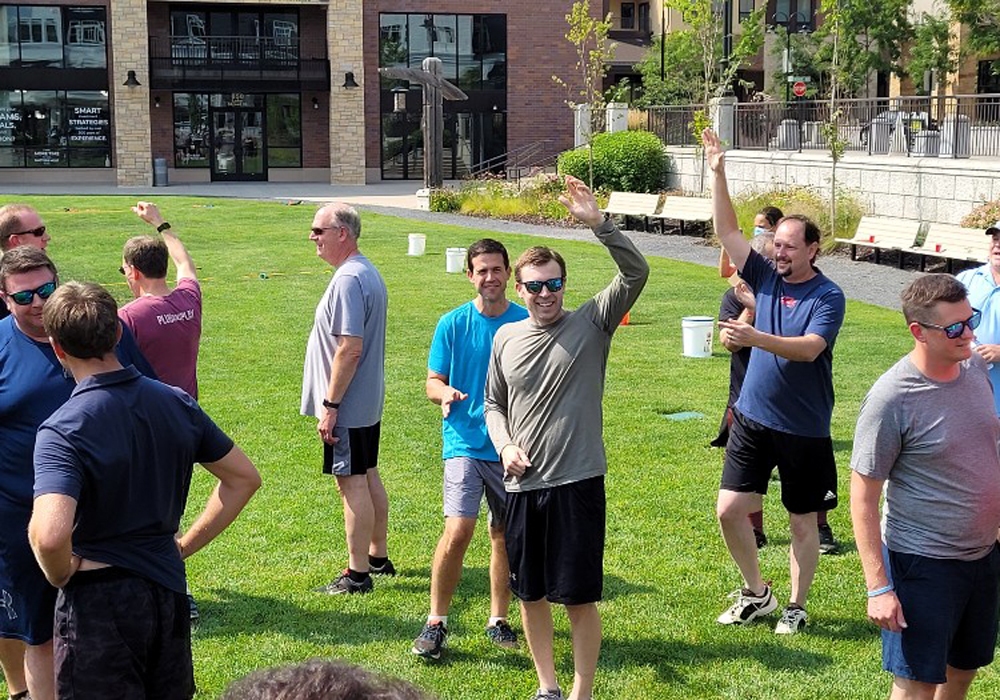 A group of people standing in a grassy area.