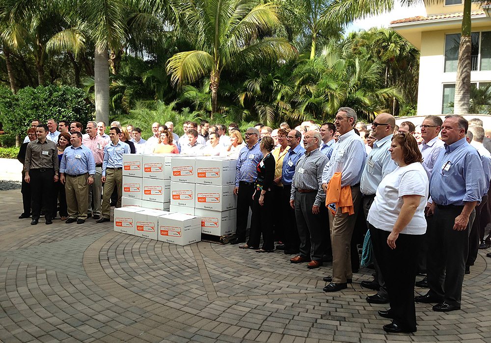 A group of people standing in front of a group of boxes.