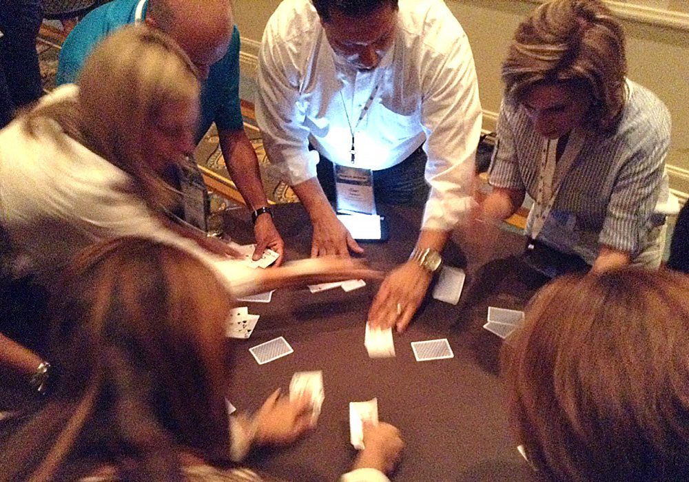 A group of people playing a game of cards.