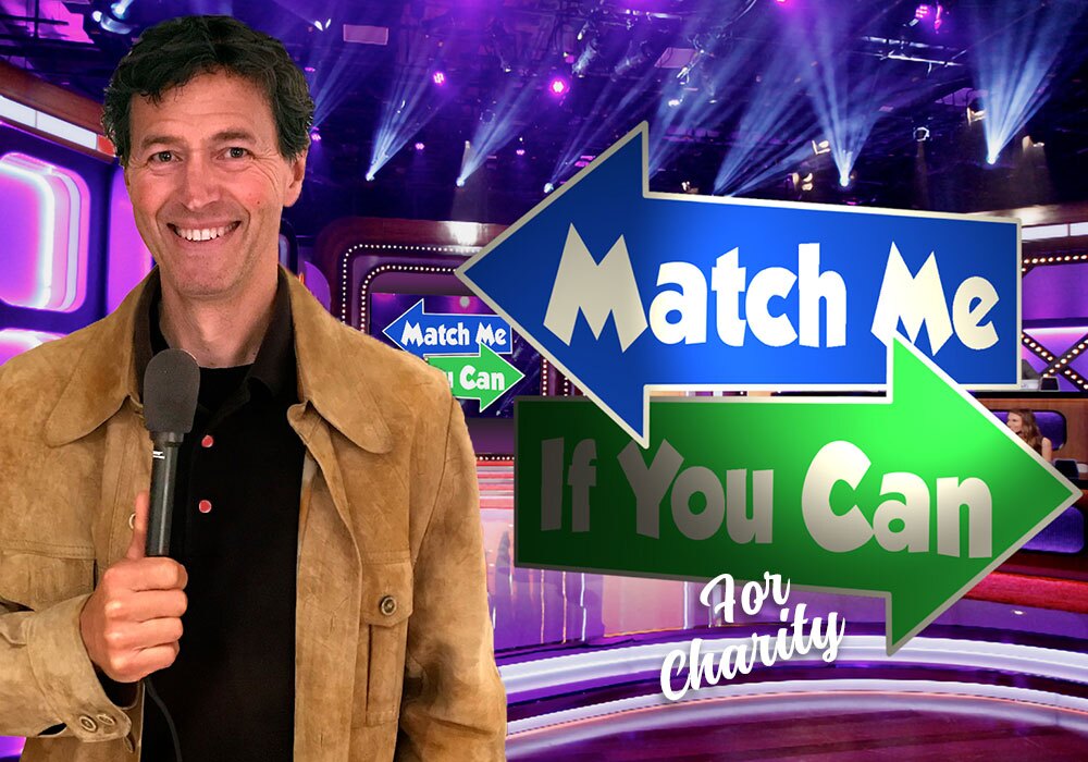 A man holding a microphone stands in front of a game show set with a "Match Me If You Can For Charity" sign featuring blue and green arrows.