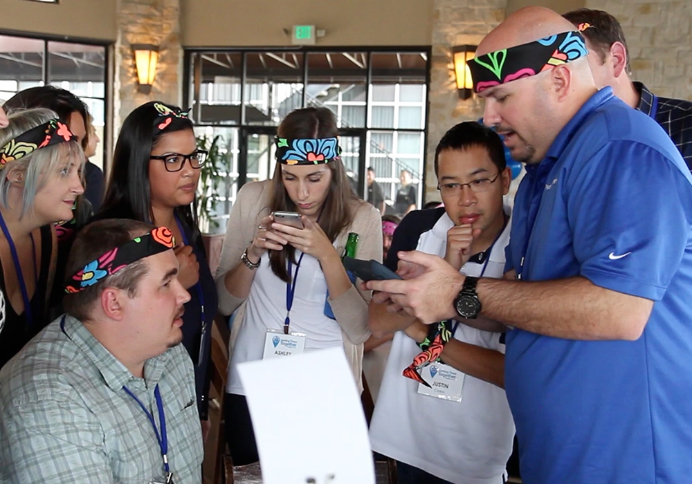 A group of people looking at a cell phone.