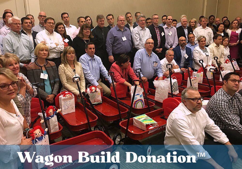 A group of people posing for a picture with the words wagon build donation.