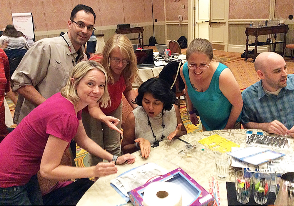 A group of people standing around a table.
