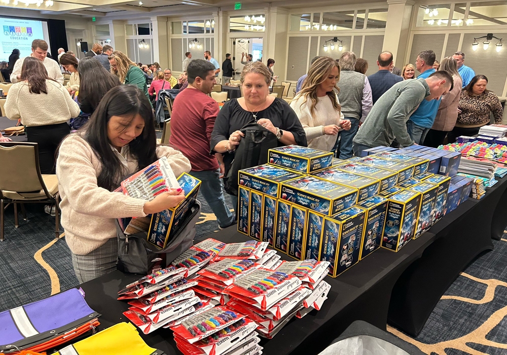 A group of people standing around a table full of boxes.