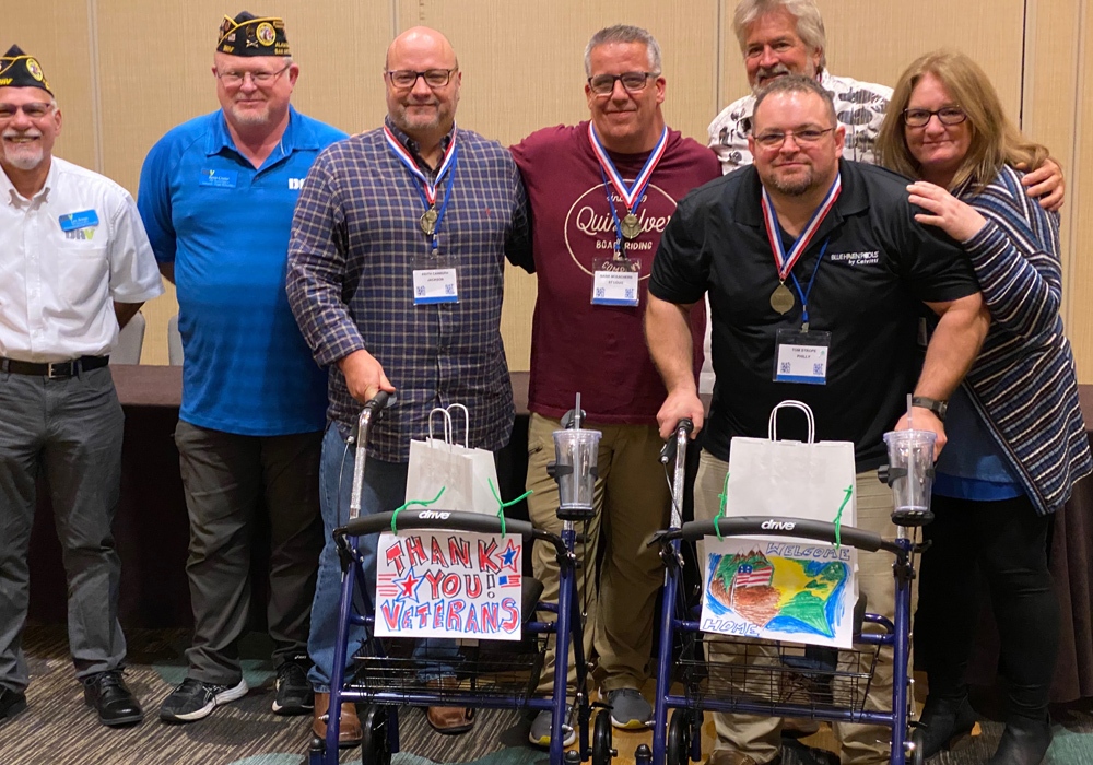 A group of veterans posing for a photo with their medals.