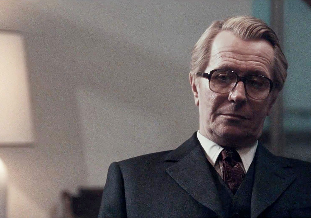 A man in a suit and tie looking at a lamp.