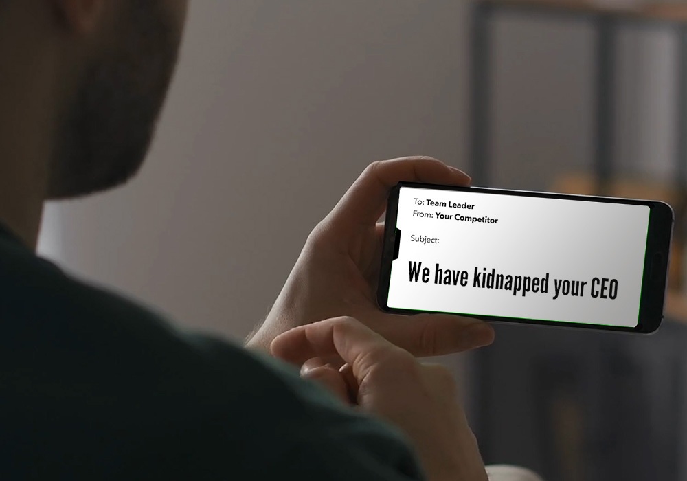 A man is holding up a smartphone with a message on it.