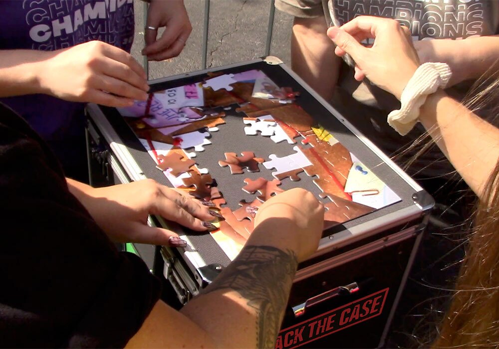 A group of people playing a game of jigsaw on a table.