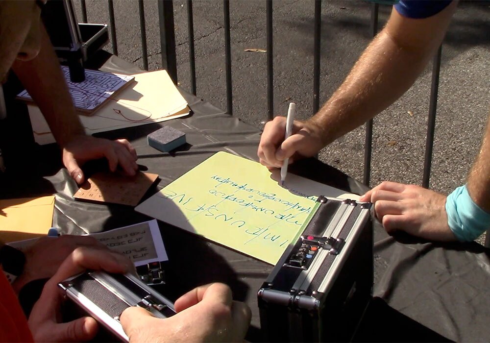 A group of people writing on a piece of paper.