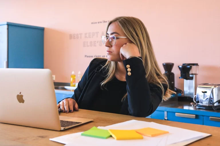 A woman sitting at a desk with a laptop, engaged in team building activities.