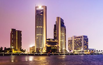 A view of a city at dusk with tall buildings in the background.