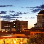 A city skyline at dusk with tall buildings in the background.