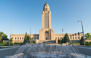 A fountain in front of a building with a clock tower.
