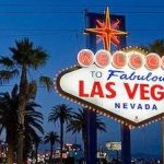 The las vegas sign is lit up at night.