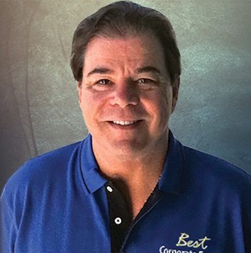 A man in a blue shirt is smiling for the camera.