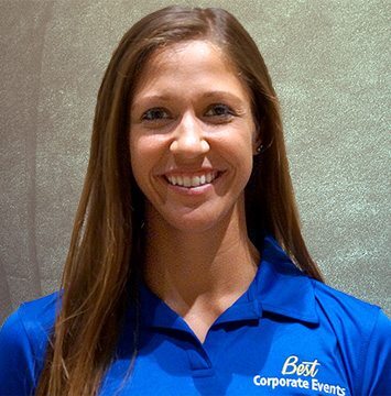 A woman in a blue shirt is smiling.