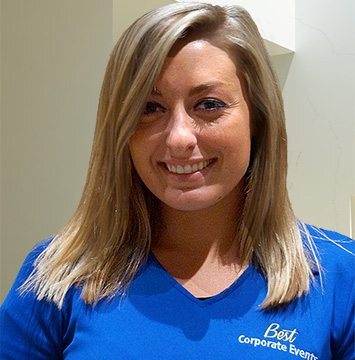 A woman in a blue shirt smiling for the camera.