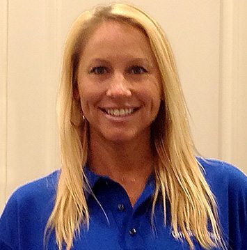 A woman in a blue shirt smiling for the camera.