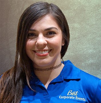 A woman in a blue polo shirt smiling.